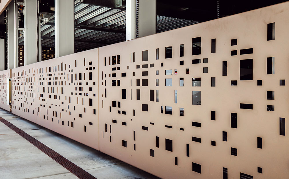 Brown metal fence with abstract cutouts by BOK Modern