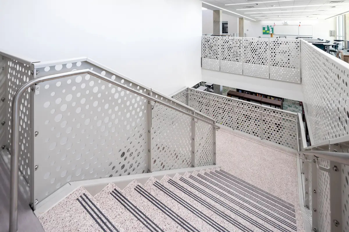 Silver metal staircase and guardrail by BOK Modern installed at school facility